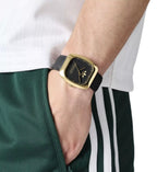 Adidas AOSY24528 watch worn on a wrist beside green trousers.