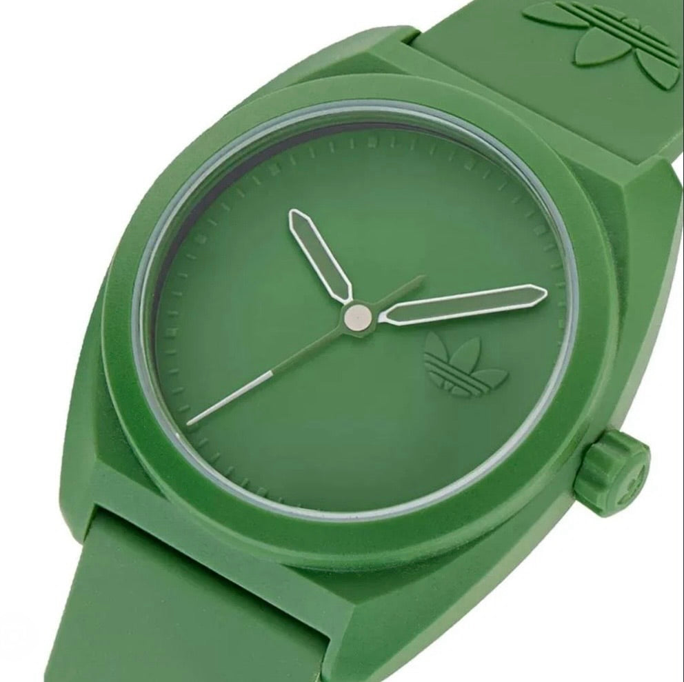 Close-up of Adidas AOST24053 watch showing the green dial, hands and trefoil detail.