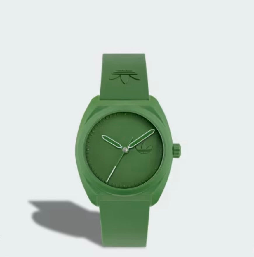 Front view of Adidas AOST24053 watch with a green dial, case and strap casting a shadow on a pale background.