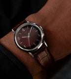 front view of Timex Mens Watch Marlin Hand Wound TW2W93300 with brown dial, leather strap and silver case on a man's wrist