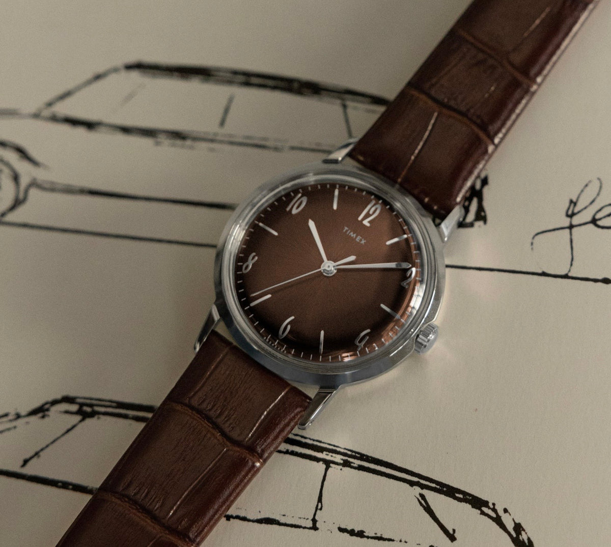 front view of Timex Mens Watch Marlin Hand Wound TW2W93300 with brown dial, leather strap and silver case laid out flat